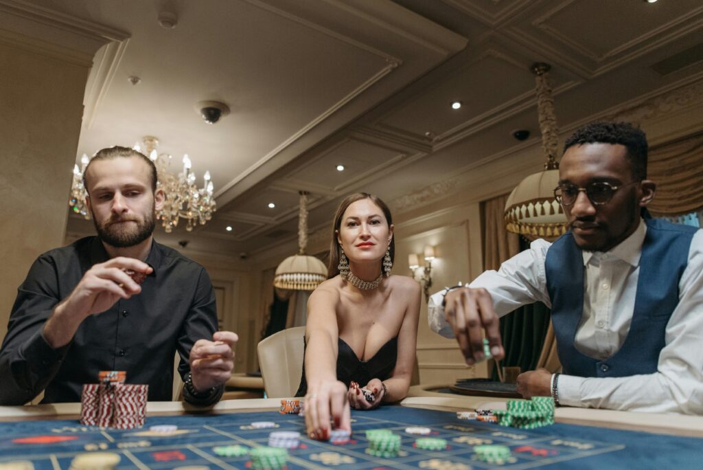 A few people gambling in the casino.