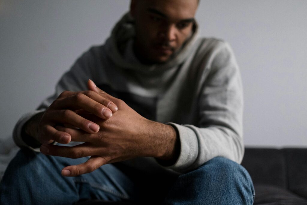 A stressed man sitting on a couch. 